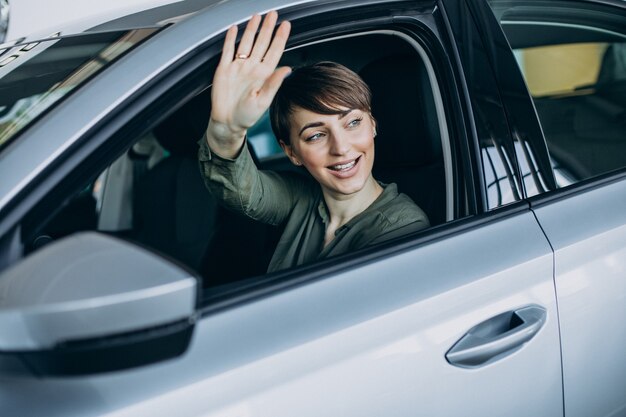 Junge Frau, die durch das Fensterauto schaut