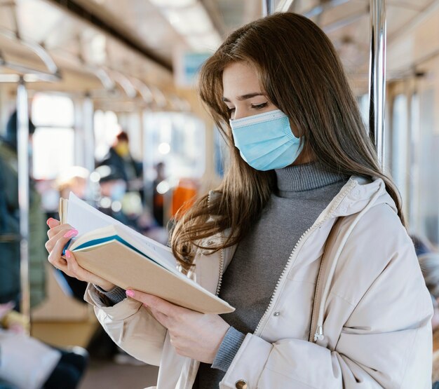 Junge Frau, die durch U-Bahn reist, die ein Buch liest