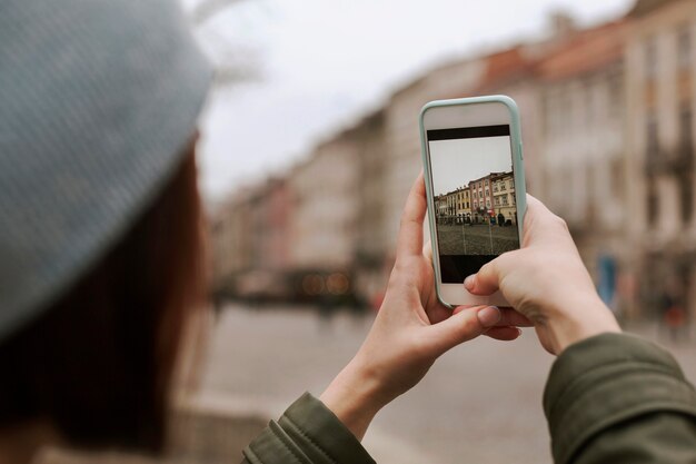 Junge Frau, die ein Foto mit ihrem Telefon macht