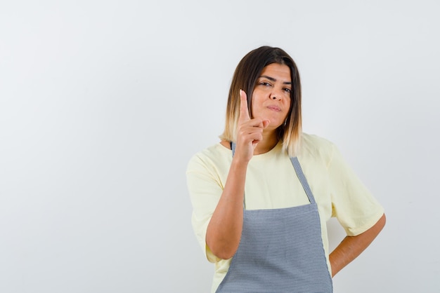 Junge Frau, die ein Handfeuerwaffenzeichen auf weißem Hintergrund hält