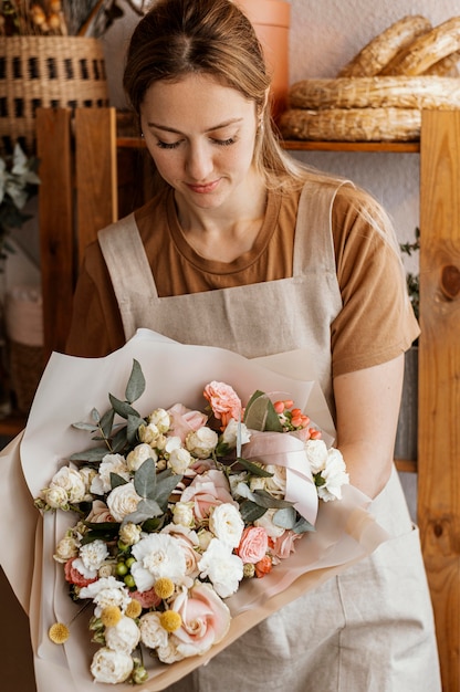 Junge Frau, die ein hübsches Blumenarrangement macht