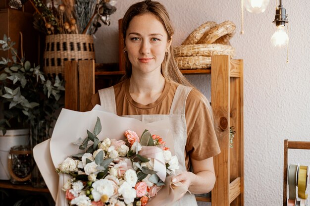 Junge Frau, die ein hübsches Blumenarrangement macht