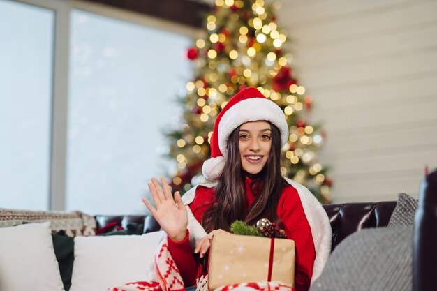 Junge Frau, die ein Weihnachtsgeschenk am Silvesterabend hält