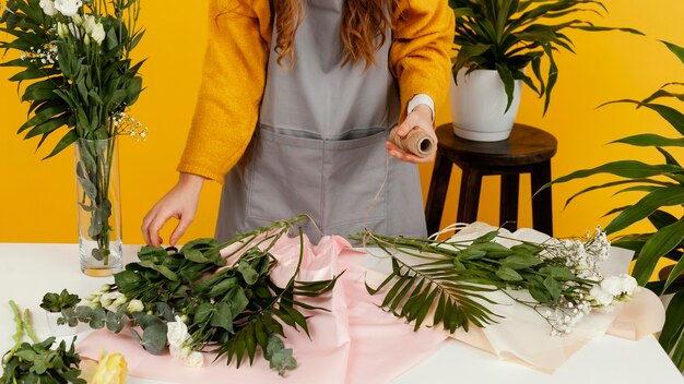 Junge Frau, die eine Blumenanordnung macht