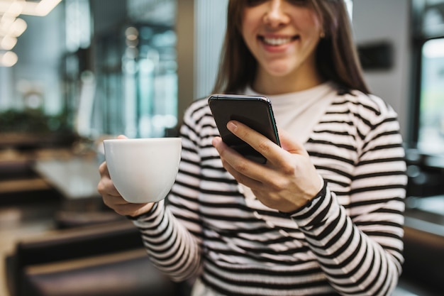 Junge Frau, die eine Kaffeetasse genießt