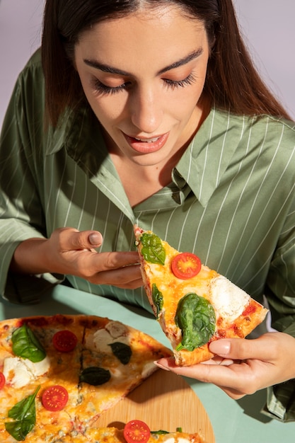 Kostenloses Foto junge frau, die eine köstliche pizza genießt