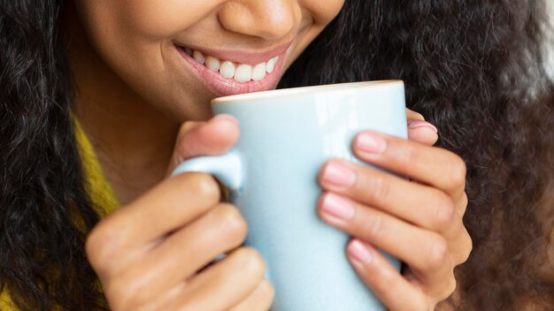 Junge Frau, die eine Tasse Kaffee genießt