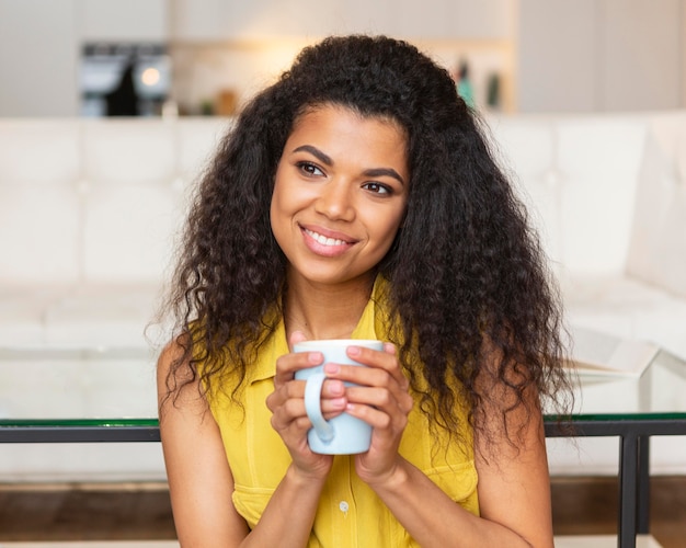 Junge Frau, die eine Tasse Kaffee genießt