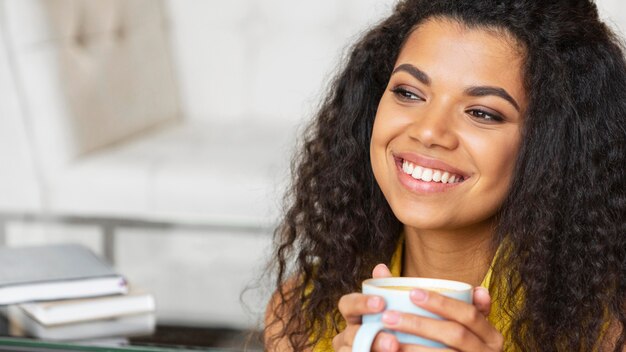 Junge Frau, die eine Tasse Kaffee genießt