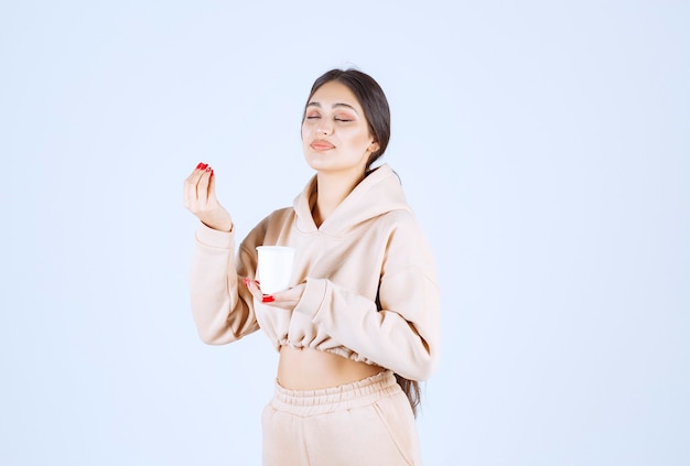 Junge Frau, die eine Tasse Kaffee hält und riecht