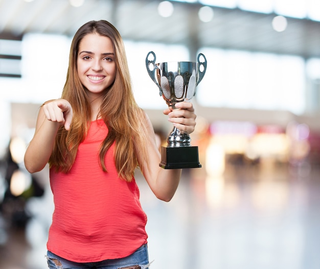 junge Frau, die eine Trophäe auf einem weißen Hintergrund