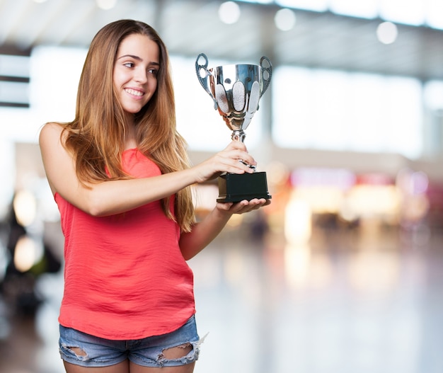 junge Frau, die eine Trophäe auf einem weißen Hintergrund