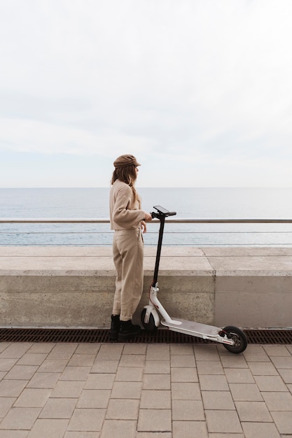 Junge Frau, die einen Elektroroller reitet