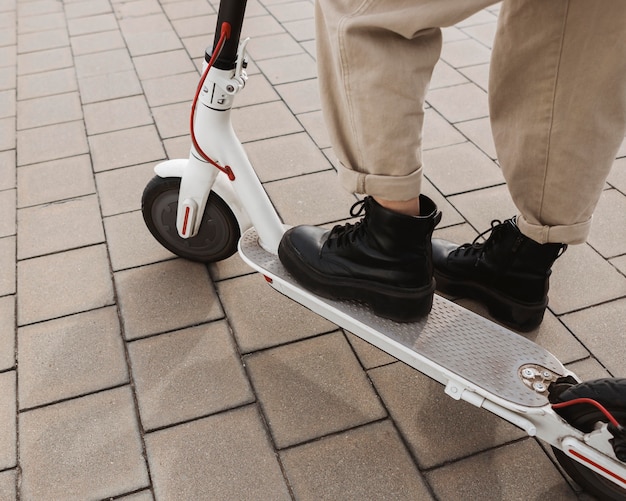 Junge Frau, die einen Elektroroller reitet