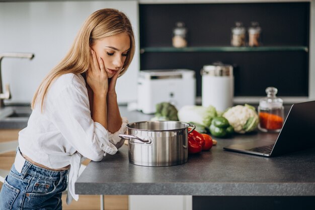 Junge Frau, die Essen an der Küche zubereitet