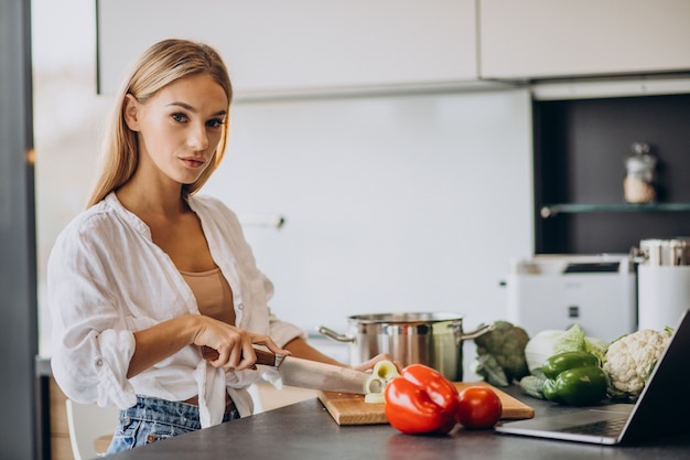 Junge Frau, die Essen an der Küche zubereitet