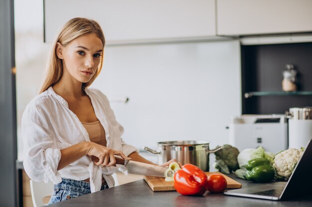 Junge Frau, die Essen an der Küche zubereitet