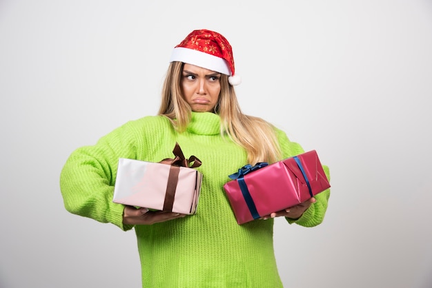 Junge Frau, die festliche Weihnachtsgeschenke trägt.