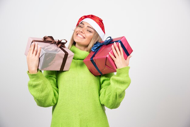 Kostenloses Foto junge frau, die festliche weihnachtsgeschenke trägt.