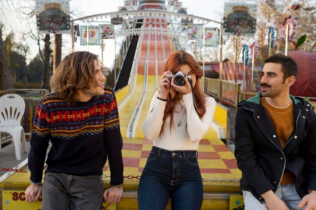 Junge Frau, die Fotos in der Nähe ihrer Freunde macht