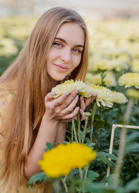 Junge Frau, die für Blumen sich interessiert