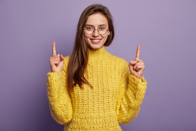 Junge Frau, die gelben Pullover trägt