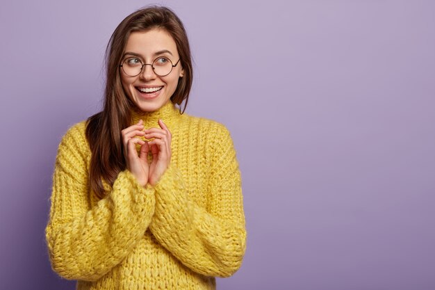 Junge Frau, die gelben Pullover trägt