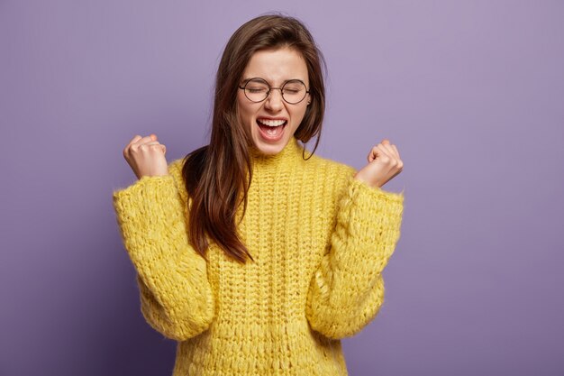 Junge Frau, die gelben Pullover trägt