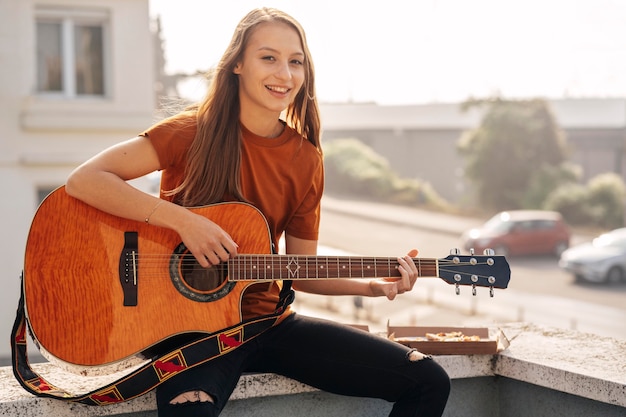 Kostenloses Foto junge frau, die gitarre spielt