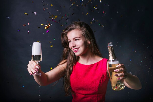 Junge Frau, die Glas Champagner betrachtet