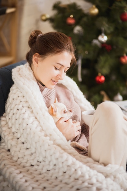 Junge Frau, die ihr häusliches Leben genießt. Wohnkomfort, Winter- und Urlaubszeit