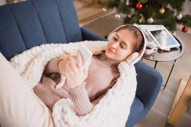 Junge Frau, die ihr häusliches Leben genießt. Wohnkomfort, Winter- und Urlaubszeit