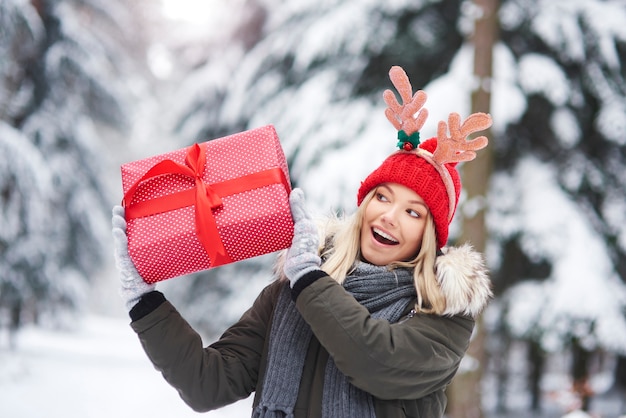 Junge Frau, die ihr Weihnachtsgeschenk schüttelt