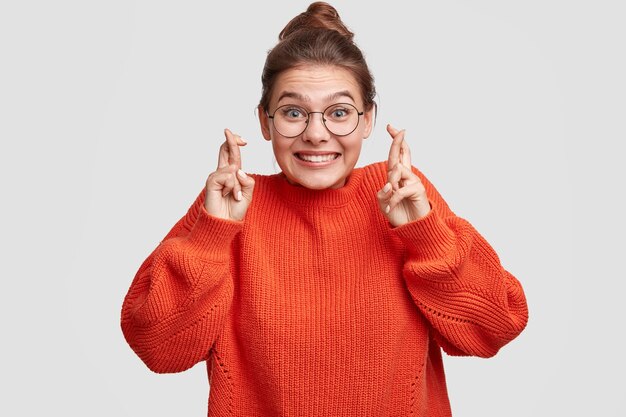 Junge Frau, die ihre Haare in einem Brötchen und im großen Pullover trägt