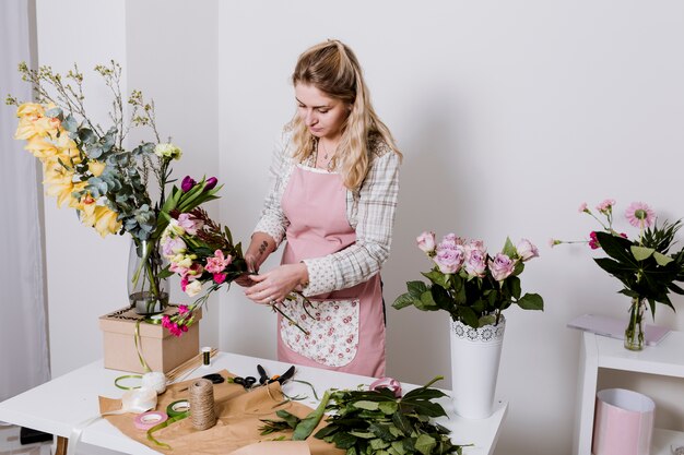 Junge Frau, die im Blumenladen arbeitet