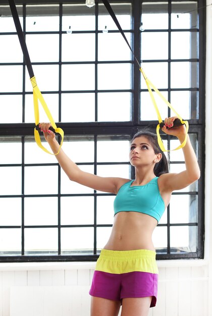 Junge Frau, die im Fitnessstudio trainiert