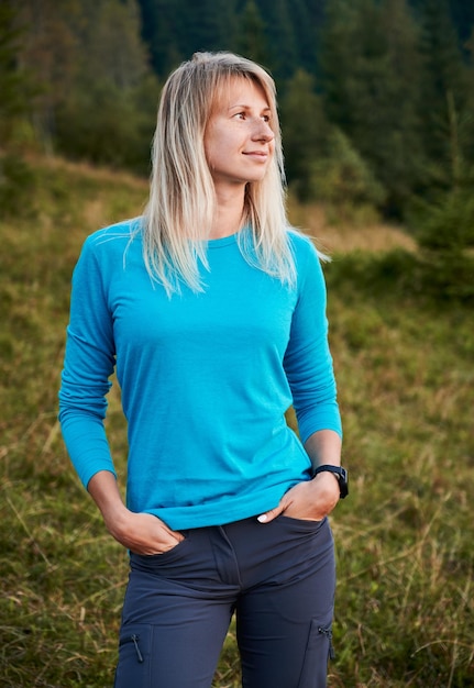 Kostenloses Foto junge frau, die im freien steht und nach rechts in die ferne blickt