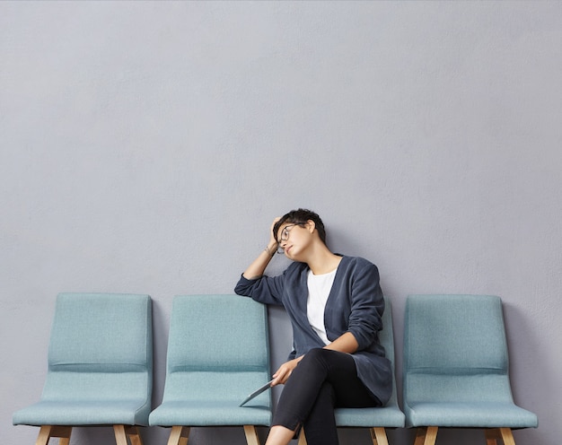 Kostenloses Foto junge frau, die im wartezimmer sitzt