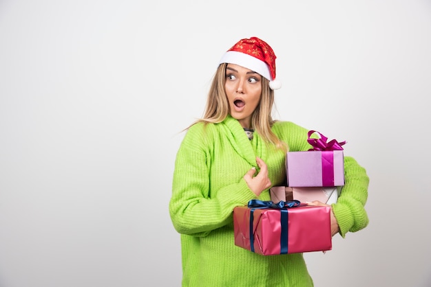 Kostenloses Foto junge frau, die in den festlichen weihnachtsgeschenken der hände hält.