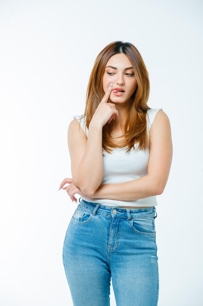 Junge Frau, die in denkender Pose steht