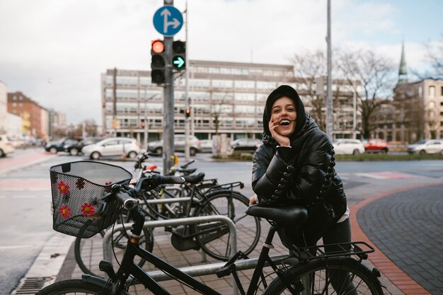 Junge Frau, die in einem Parkplatz mit Fahrrädern aufwirft