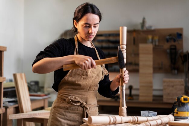 Junge Frau, die in einer Holzstichwerkstatt arbeitet