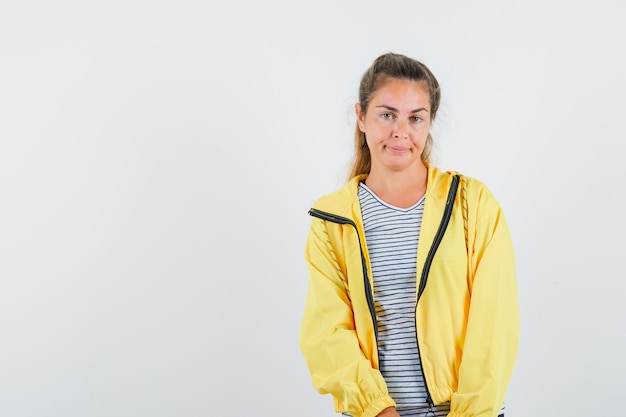 Kostenloses Foto junge frau, die kamera im t-shirt, in der jacke betrachtet und unzufrieden schaut. vorderansicht.