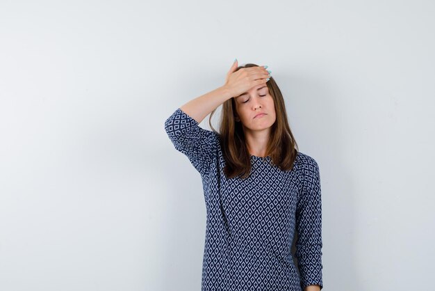 Junge Frau, die Kopfschmerzen auf weißem Hintergrund hat