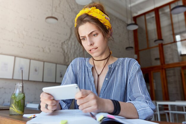 Junge Frau, die Kopftuch trägt und im Café studiert