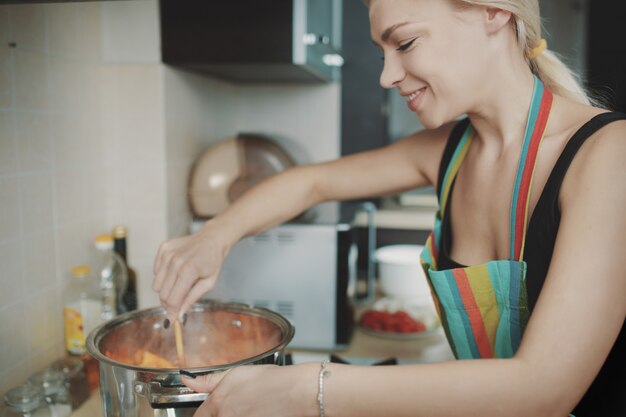 Junge Frau, die Kürbissuppe zubereitet