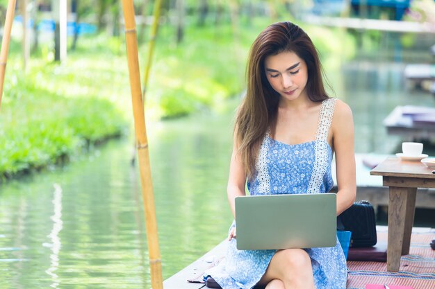 Junge Frau, die Laptop im Park verwendet