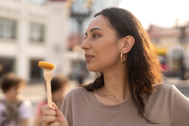 Junge Frau, die leckeres Streetfood genießt