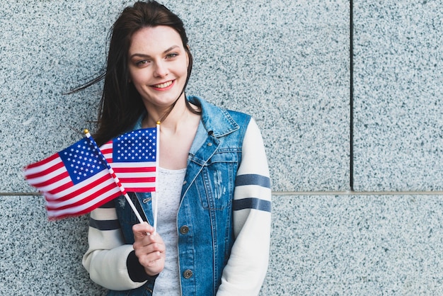 Junge Frau, die mit amerikanischen Flaggen aufwirft
