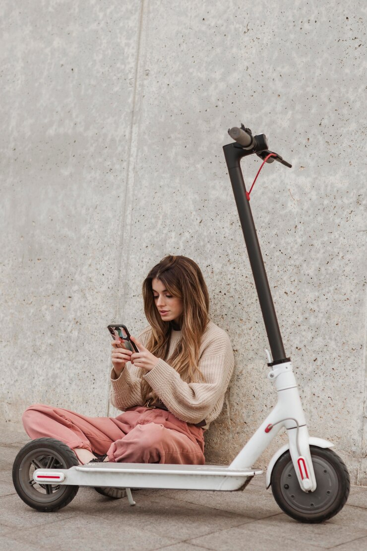 Kostenlose Foto junge frau, die mit einem elektroroller aufwirft